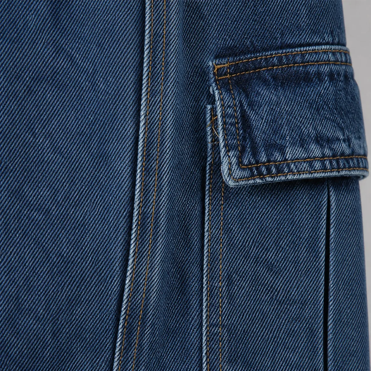 Men's jeans denim surface, seam and cargo pocket close-up